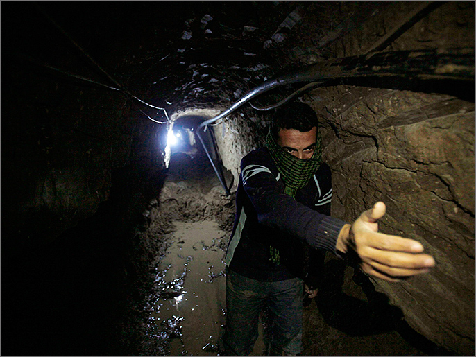 A Palestinian works inside a smuggling tunnel flooded by Egyptian forces, beneath the Egyptian-Gaza border in Rafah, in the southern Gaza Strip February 19, 2013. Egypt will not tolerate a two-way flow of smuggled arms with the Gaza Strip that is destabilising its Sinai peninsula, a senior aide to its Islamist president said, explaining why Egyptian forces flooded sub-border tunnels last week. To match Interview PALESTINIANS-TUNNELS/EGYPT/ REUTERS/Ibraheem Abu Mustafa (GAZA - Tags: POLITICS CIVIL UNREST)