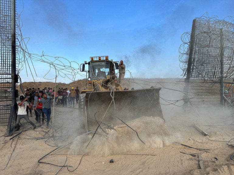 Palestinians break into the Israeli side of Israel-Gaza border fence after gunmen infiltrated areas of southern Israel, October 7, 2023. REUTERS/Mohammed Fayq Abu Mostafa NO RESALES. NO ARCHIVES.