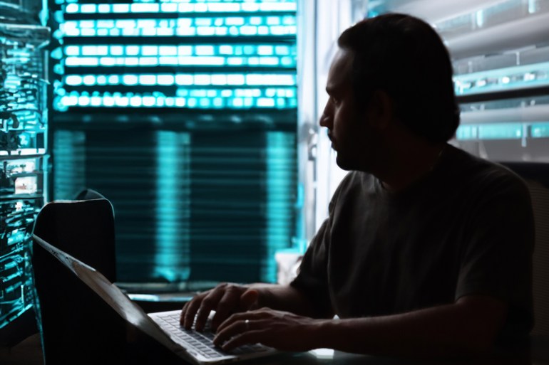 Stock photo showing close-up view of computer hacker programmer typing on laptop keyboard, concept for cyber war hacking technology, encryption coding, Internet crime, software programming, digital data analysis.