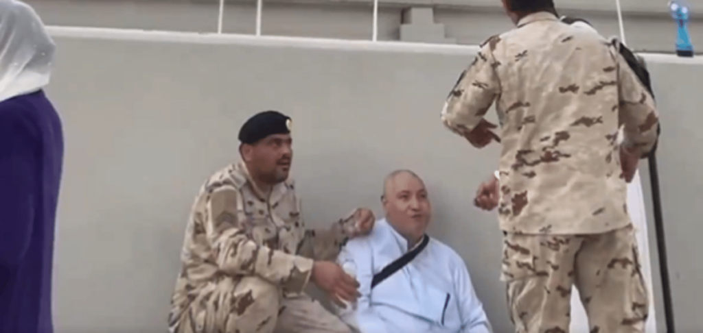أحد رجال الأمن يقدم المساعدة لحاج يعاني من هبوط حاد في السكر