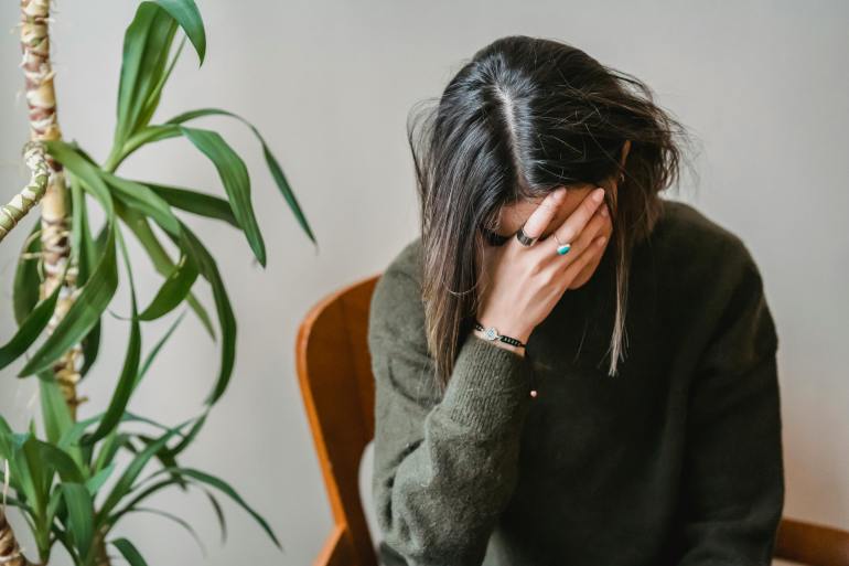 Worried young woman covering face with hand