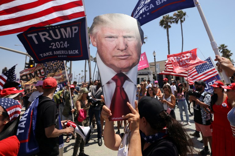 A pro-Trump supporter holds a portrait of former President Donald Trump during a demonstration in support of former U.S. President Donald Trump who was shot the previous day in an assassination attempt during a rally in Pennsylvania, in Huntington Beach, California, U.S. July 14, 2024. REUTERS/Etienne Laurent