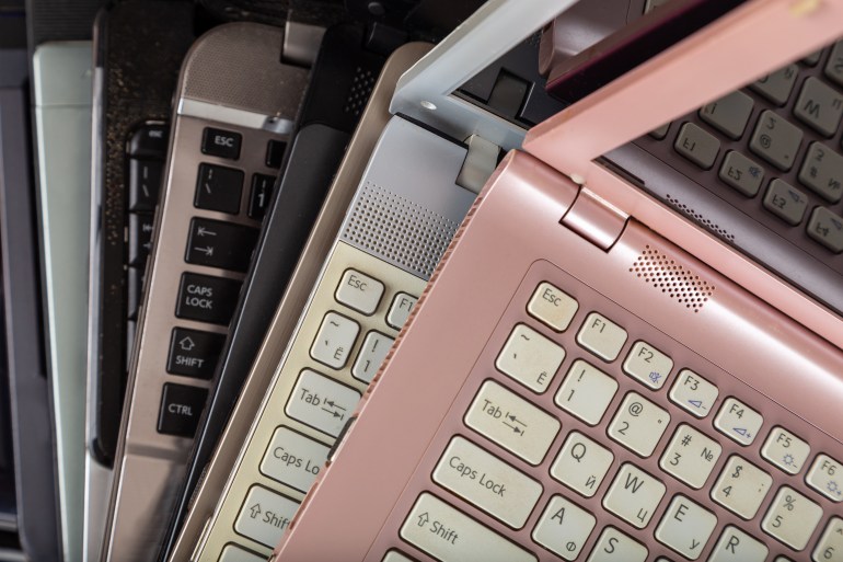 Stack of used laptops in different colors and models. Tha notebooks for repair and service.