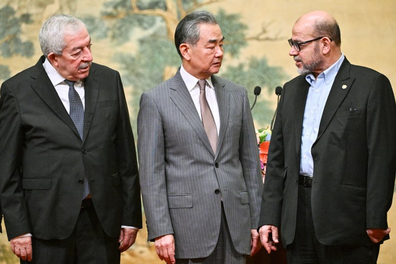 (L-R) Mahmoud al-Aloul, Vice Chairman of the Central Committee of Palestinian organisation and political party Fatah, China's Foreign Minister Wang Yi, and Mussa Abu Marzuk, senior member of the Palestinian Islamist movement Hamas, attend an event at the Diaoyutai State Guesthouse in Beijing on July 23, 2024. - China's Foreign Minister Wang Yi on July 23 hailed an agreement by 14 Palestinian factions to set up an "interim national reconciliation government" to govern Gaza after the war. (Photo by Pedro Pardo / AFP)