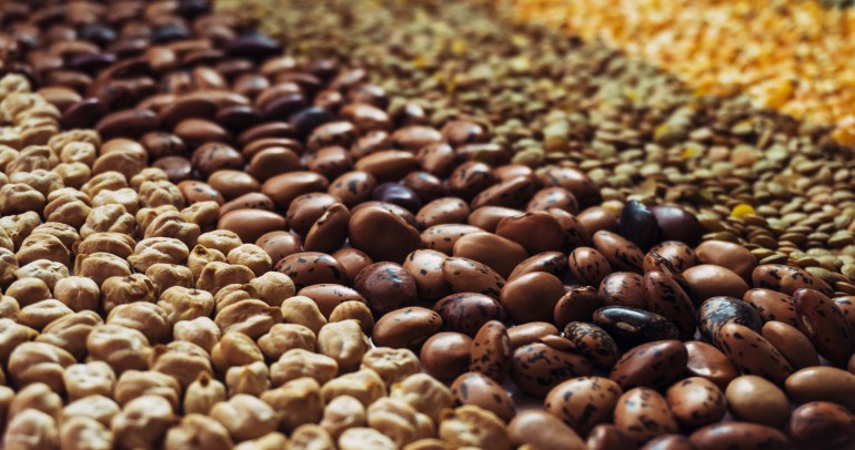 Background made with dry grains and seeds with a diagonal perspective, including chickpeas, beans, lentils, pop corn and peas, representing food sovereignty and the importance in the covid era