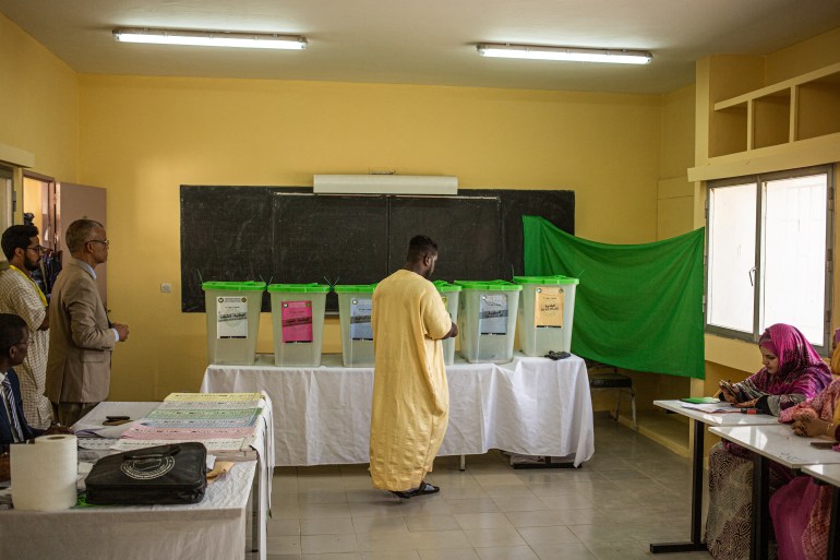 A man walks to the ballot boxes to cast his ballot at a polling station in Nouakchott on May 13, 2023. Voters in the West African nation of Mauritania began casting ballots on May 13, 2023 in the first legislative and local elections since President Mohamed Ould Ghazouani came to power in 2019. (Photo by MED LEMINE RAJEL / AFP)