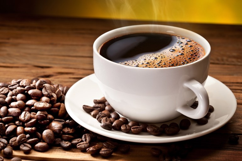 Coffee cup and saucer on a wooden table. Dark background.