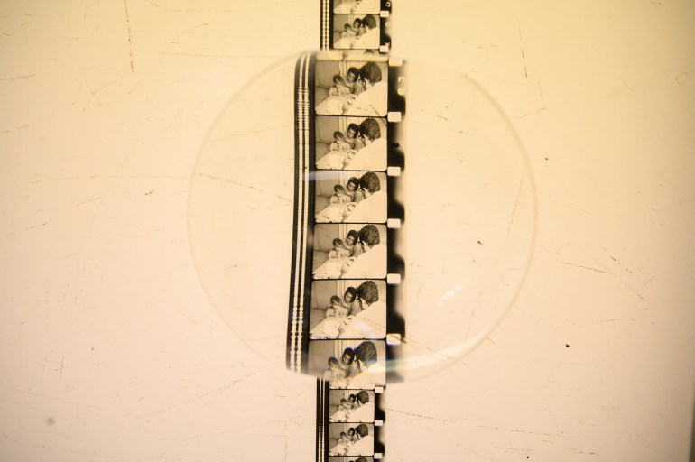 This photograph shows a reel of film showing scenes of daily life in Palestine, part of a collection of 40 Palestinian films made between 1960 and 1980, is displayed under a magnifying glass at the Conservation and Research Center of the Toulouse Cinematheque, in Toulouse, southwestern France, on August 1, 2024. - In the early 1980s, the Palestinian Film Institute in Beirut, where around a hundred militant films were stored, was bombed by Israel during the Lebanon war. Its director, Khadijeh Habashneh, fled the country, leaving the reels behind. Almost 40 years later, the 79-year-old former director of the Institute has managed to collect 40 short and medium-length films, in 16 and 30 mm formats, which will be shown to the general public at the Cine Palestine festival in Toulouse. (Photo by Ed JONES / AFP)