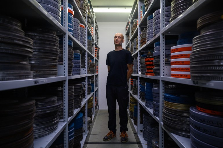 Archivist Matthieu Larroque poses during a photo session at the Conservation and Research Center of the Toulouse Cinematheque, in Toulouse, southwestern France, on August 1, 2024. - In the early 1980s, the Palestinian Film Institute in Beirut, where around a hundred militant films were stored, was bombed by Israel during the Lebanon war. Its director, Khadijeh Habashneh, fled the country, leaving the reels behind. Almost 40 years later, the 79-year-old former director of the Institute has managed to collect 40 short and medium-length films, in 16 and 30 mm formats, which will be shown to the general public at the Cine Palestine festival in Toulouse. (Photo by Ed JONES / AFP)