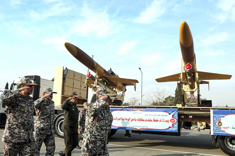 A handout picture provided by the Iranian Army office on December 10, 2023, shows Iranian army officials inspecting Iranian homemade Karrar drones displayed during an inauguration ceremony in Tehran. (Photo by Handout / Iranian Army office / AFP) / XGTY / RESTRICTED TO EDITORIAL USE - MANDATORY CREDIT