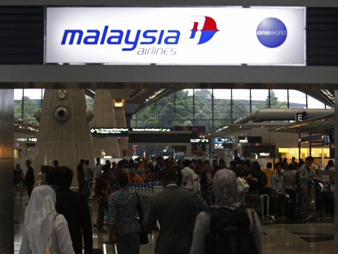 Passengers queue up at the Malaysia Airlines ticketing booth at the Kuala Lumpur International Airport in Sepang March 9, 2014. A missing Malaysia Airlines jetliner may have turned back from its scheduled route before vanishing from radar screens, military officers said on Sunday, deepening the mystery surrounding the fate of the plane and the 239 people aboard. REUTERS/Edgar Su (MALAYSIA - Tags: DISASTER TRANSPORT TRAVEL)