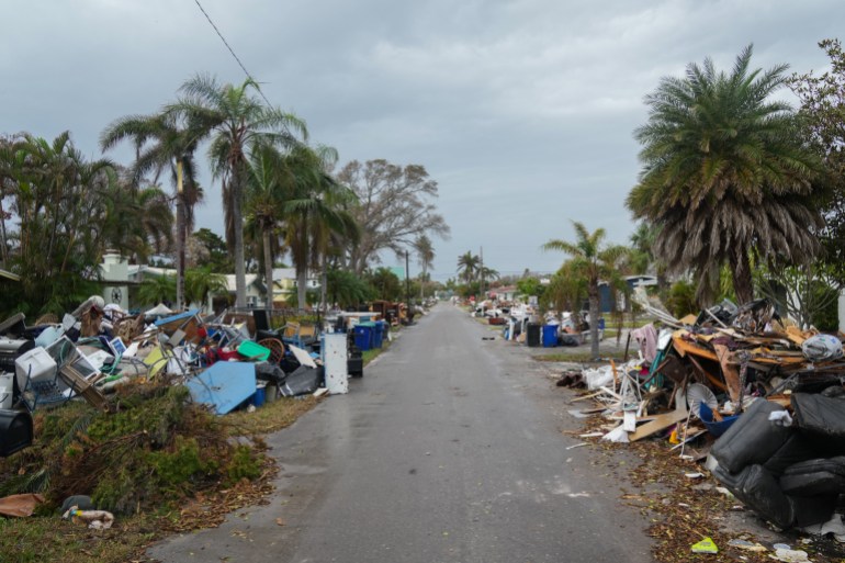 Debris from Hurricane Helene lines a street in the Redington Beach section of St. Petersburg, Florida, on October 8, 2024, ahead of Hurricane Milton's expected landfall. - Milton regained power on October 8 to become a Category 5 storm with maximum sustained winds of 165 mph (270 kph) as it barrels towards west-central coast of Florida and is forecast to make landfall late October 9, according to the National Hurricane Center. (Photo by Bryan R. SMITH / AFP)