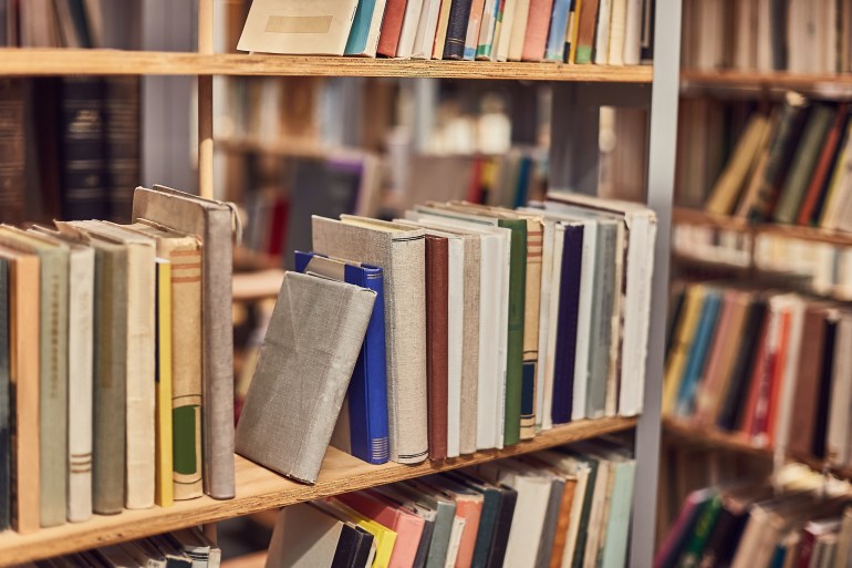 Many books on the shelves of a library