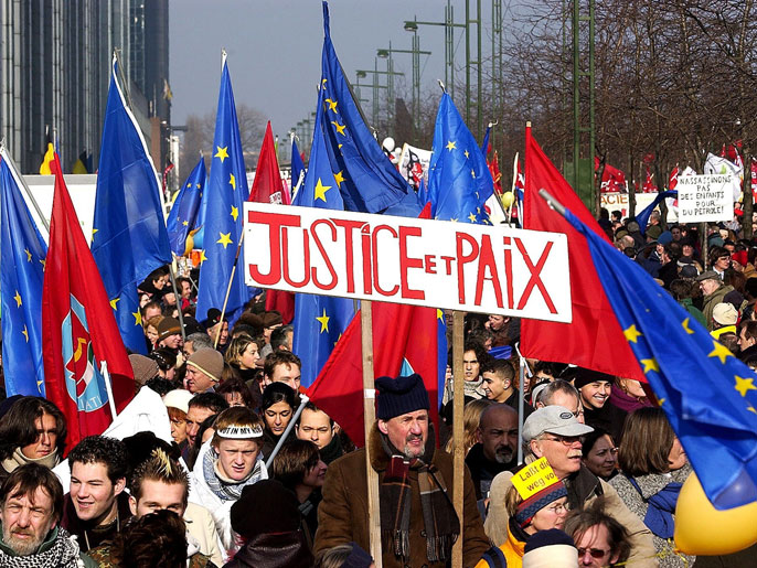 A protester holds a banner reading `Justice and Peace' as some 35.000 people demonstrate in Brussels against a possible US-led military action against Iraq, Saturday 15, February 2003