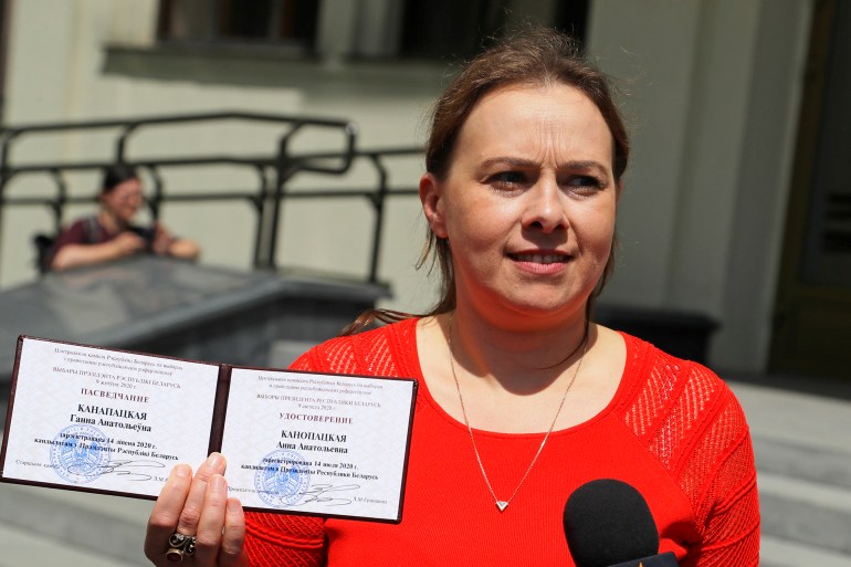 Anna Kanopatskaya shows her presidential candidate's identification card after she was registered as a candidate for the presidential elections in Minsk, Belarus, Tuesday, July 14, 2020. The election commission has cleared Belarusian President Alexander Lukashenko and four other candidates for running in a presidential vote in August, but denied registration to Lukashenko's two main aspiring challengers. (AP Photo/Sergei Grits)