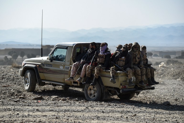 Taliban security personnel sit on the back of a vehicle near the site two days after air strikes by Pakistan in the Barmal district of eastern Paktika province on December 26, 2024. - Pakistan air strikes in an eastern border region of Afghanistan killed 46 civilians, the Taliban government said on December 25, whilst a Pakistan security official said the bombardment had targeted "terrorist hideouts". (Photo by Ahmad SAHEL ARMAN / AFP)