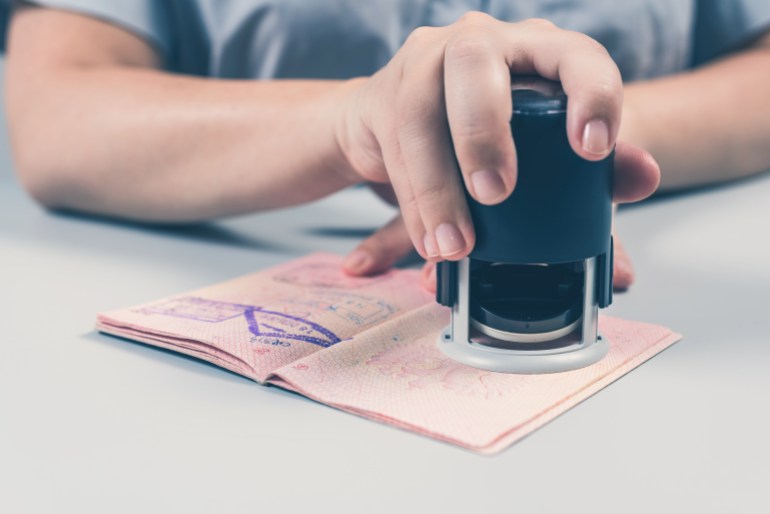 Immigration and passport control at the airport. woman border control officer puts a stamp in the passport. Concept