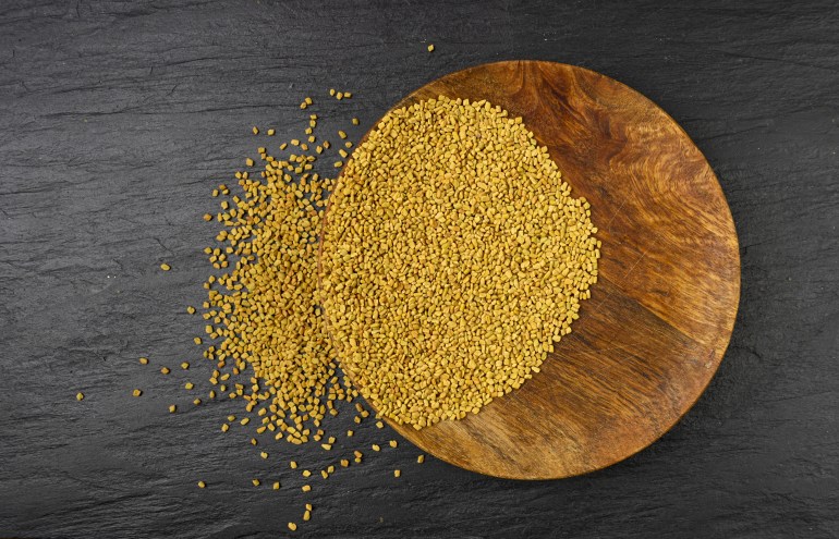 Fenugreek Seeds on Wood Plate, Dry Trigonella, Spicy Methi Dana Grains, Indian Kitchen Seasoning Ingredient, Dry Yellow Fenugreek Seed Condiment