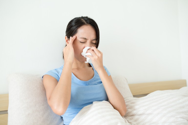 Woman suffer form headahce and runny nose