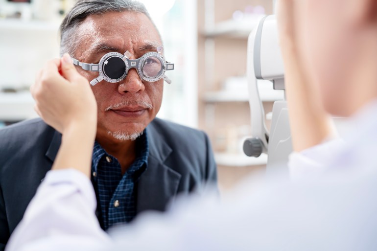 Improved Eyesight and Identifying Potential Health Issues a Comprehensive Eye Exam for Old Adults. A senior male during eye exam with optometrist by diopter tool an ophthalmology clinic.