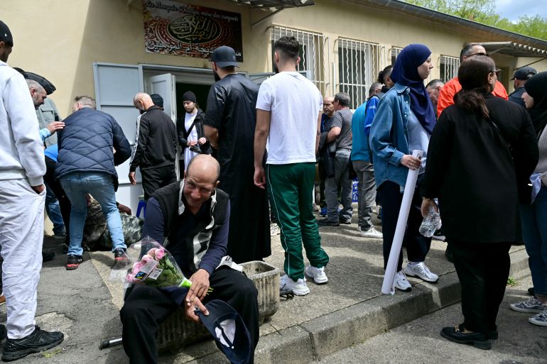 A man holds flowers outside the mosque Khadija in La Grand-Combe, southern France, on April 27, 2025, before a march in tribute to Aboubakar, a worshipper killed by several dozens of stab wounds inside the mosque on April 25.