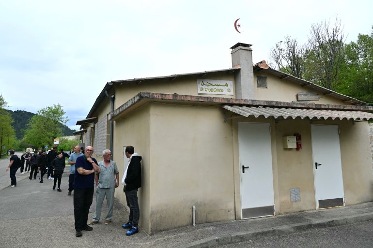People stand outside the mosque Khadija in La Grand-Combe, southern France, on April 27, 2025, following the murder of Aboubakar, a worshipper killed by several dozens of stab wounds inside the mosque on April 25.