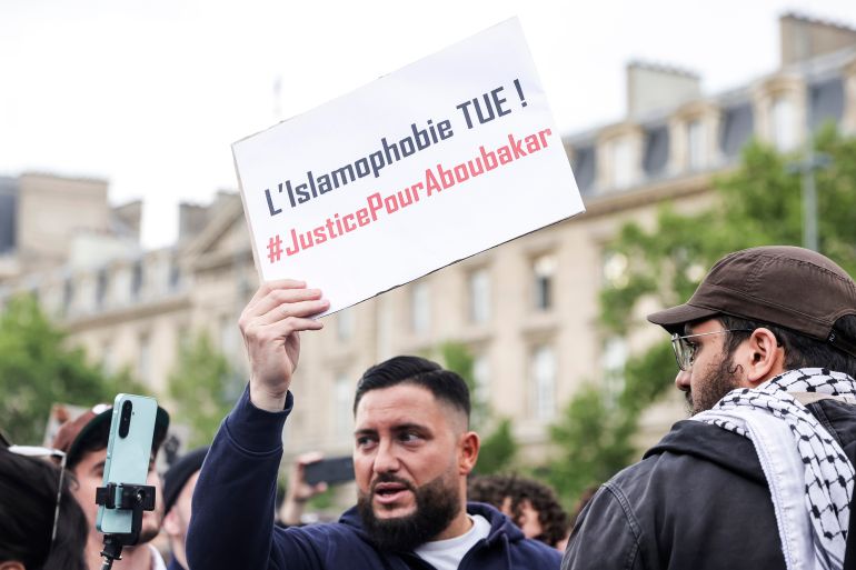 epa12059241 A man holds up a placard reading 'Islamophobia kills, justice for Aboubakar' while taking part in a rally against Islamophobia following the deadly stabbing of a man in a mosque in the south of the country, in Paris, France, 27 April 2025. Aboubakar Cisse, a young African man, was stabbed to death on 25 April in a mosque in the village of La Grand-Combe in the Gard department in southern France. EPA-EFE/TERESA SUAREZ