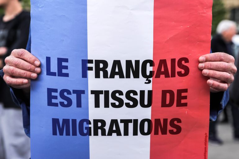 epa12059288 A participant holds a placard reading 'French is a web of migrations' while taking part in a rally against Islamophobia following the deadly stabbing of a man in a mosque in the south of the country, in Paris, France, 27 April 2025. Aboubakar Cisse, a young African man, was stabbed to death on 25 April in a mosque in the village of La Grand-Combe in the Gard department in southern France. EPA-EFE/TERESA SUAREZ