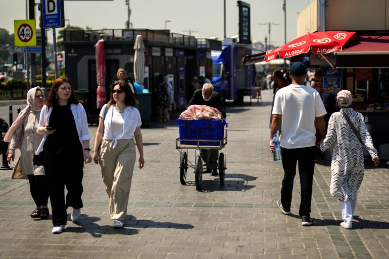 An elderly man pushes a wheels carte in a street market in Eminonu commercial district in Istanbul, Turkey, Thursday, July 20, 2023. Turkey's central bank raised its key interest rate on Thursday July 20, 2023 to 17.5% in a further sign of commitment to orthodox economic policy following elections in May. (AP Photo/Khalil Hamra)