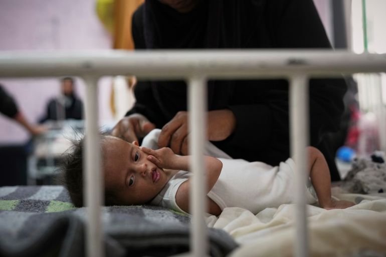 Rahma al-Qadi takes care for her 7-month-old daughter Sama, who was born with Down syndrome and suffers from malnutrition, at the malnutrition clinic in Nasser hospital, Khan Younis, Gaza, Thursday, May 1, 2025. (AP Photo/Abdel Kareem Hana)