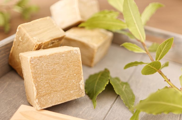 Natural soap and laurel branch (soap ingredient) in wooden box. Traditional soap from Aleppo.