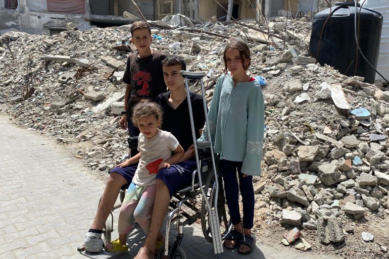 عبيدة عطوان محاطا بأخوته أمام منزلهم المدمر بمدينة دير البلح وسط قطاع غزة-رائد موسى-دير البلح-الجزيرة نت