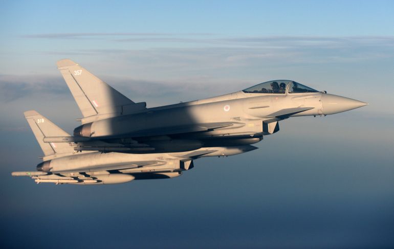 British Royal Air Force's Typhoon Eurofighter jets demonstrate the interception of a Belgian air force transport plane as they fly over Britain