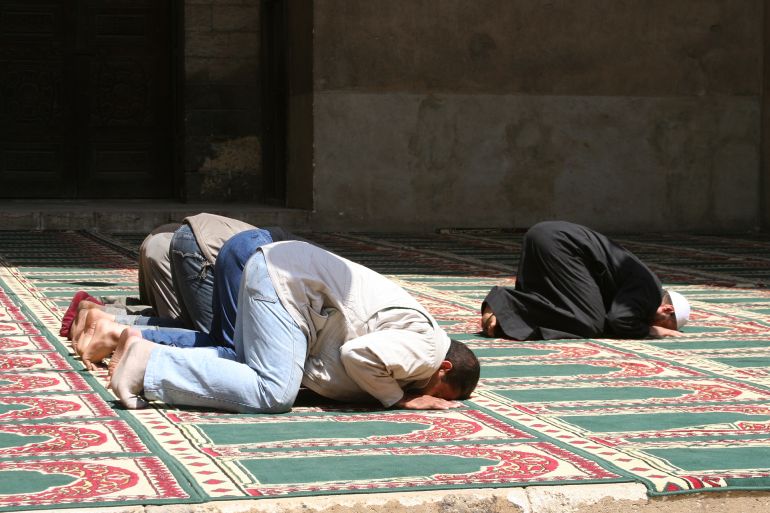 Facing Mecca, deep in prayer, traditional carpet